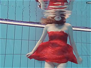 crimson dressed teenage swimming with her eyes opened